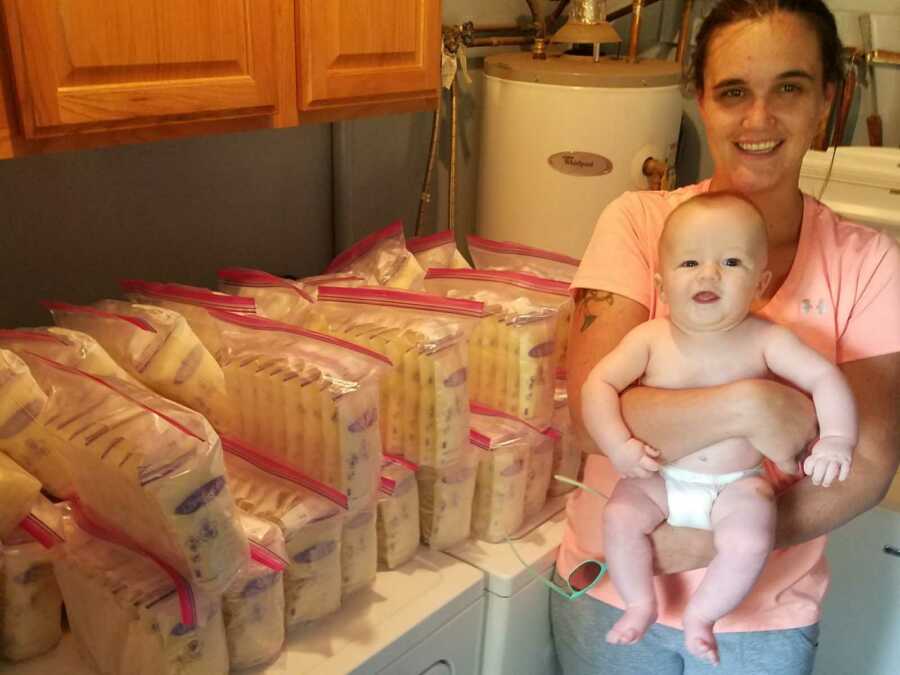 mom holding baby next to bags of breast milk
