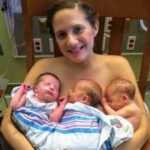 mom holding newborn triplets