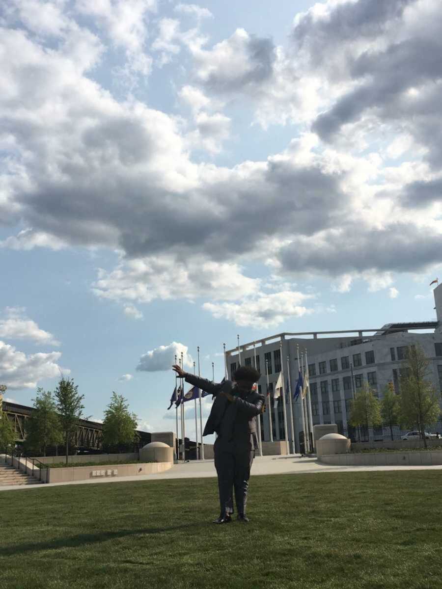 Teen boy dabbing on grassy Atlanta lawn