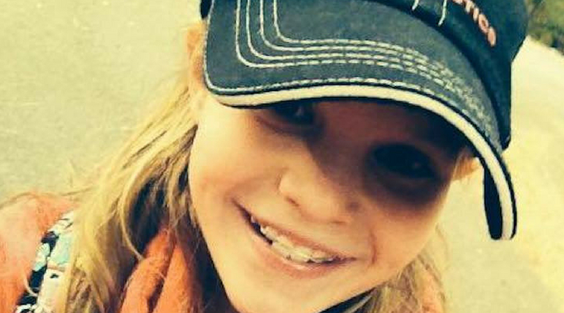 teen girl smiling outside wearing hat
