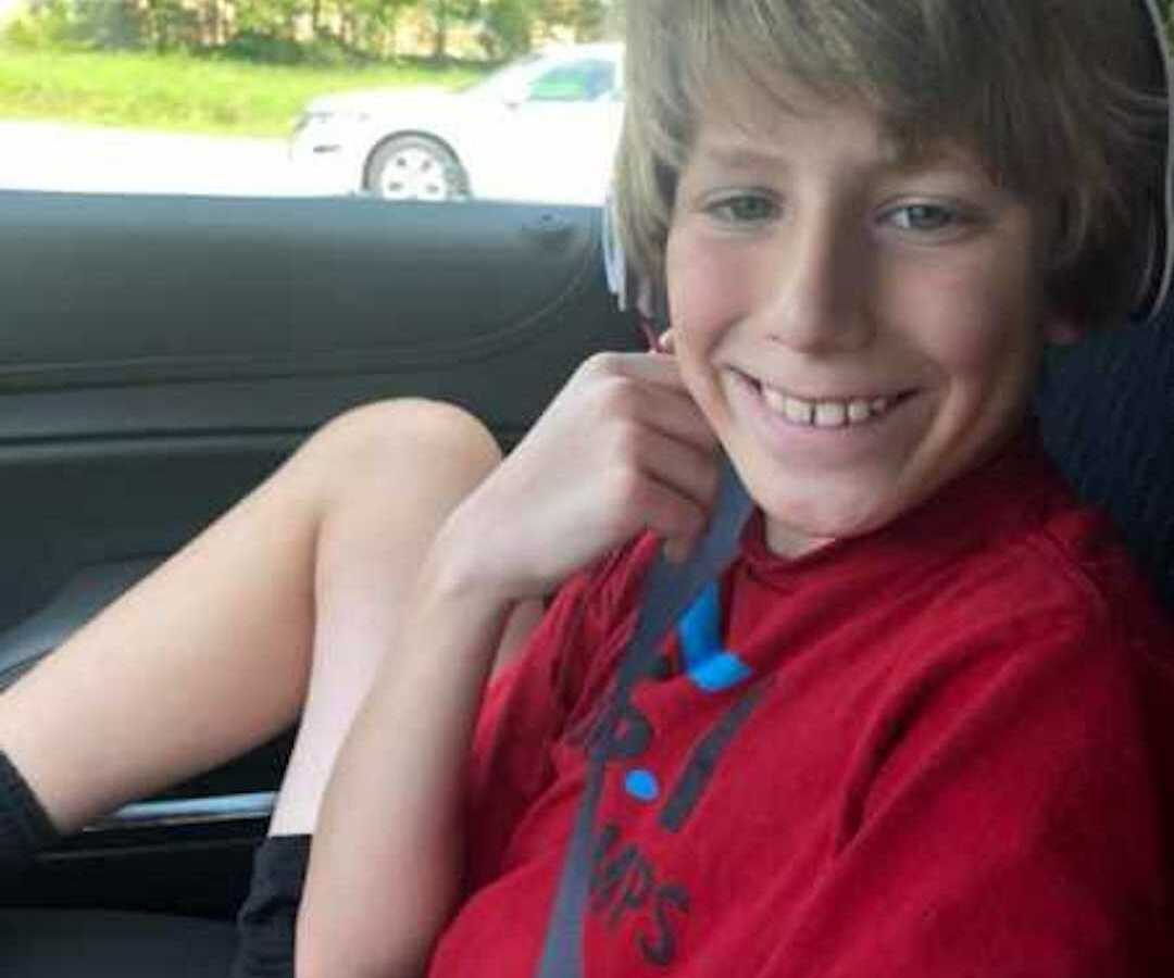 young boy smiling in car