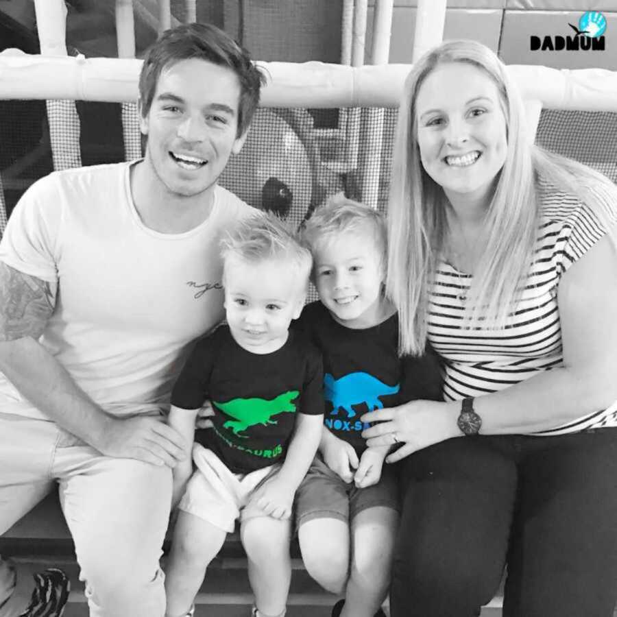 black and white photo of family sitting on ground