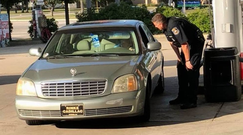 police officer standing at elderly woman's car door