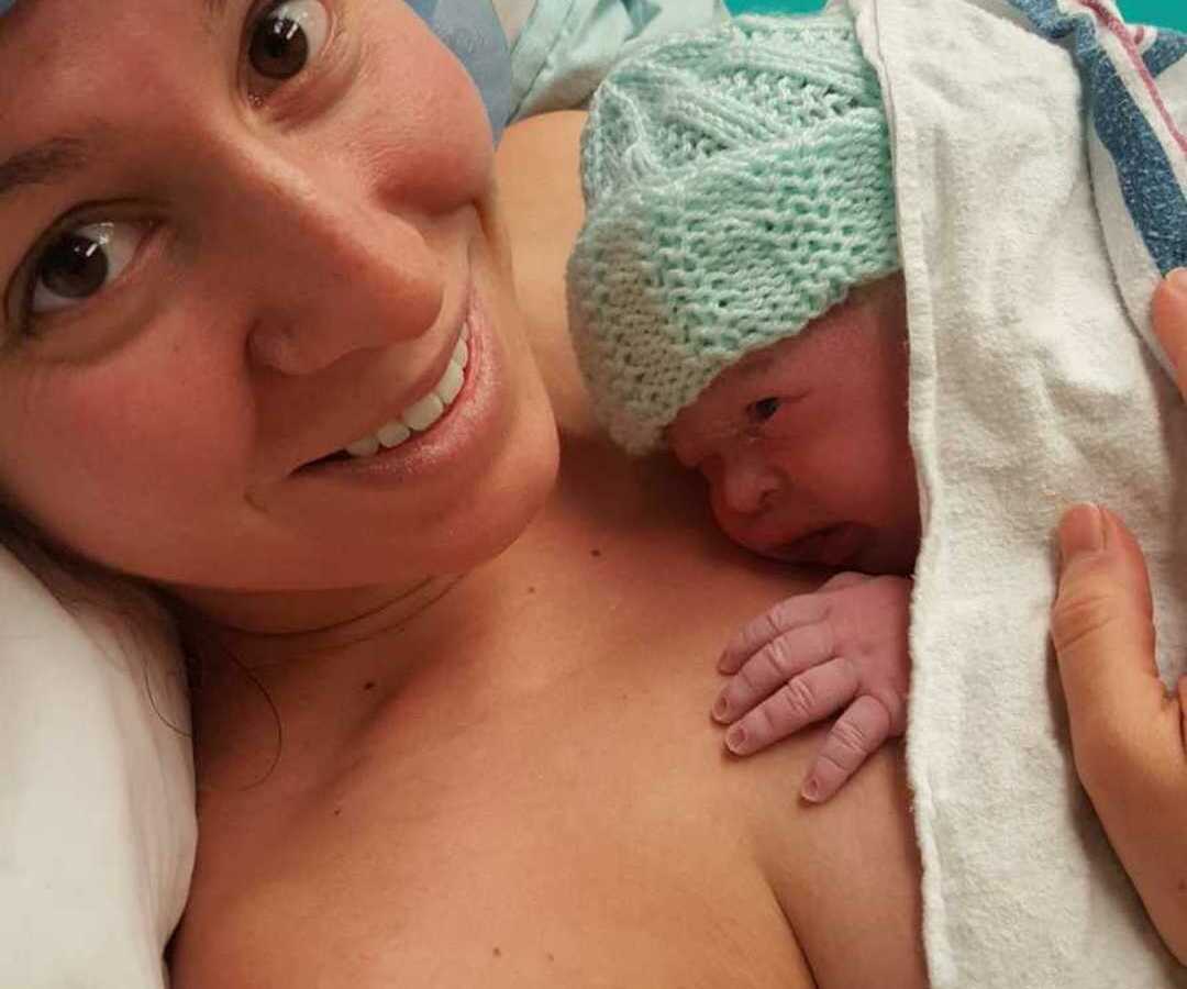 mom in hospital bed holding newborn baby