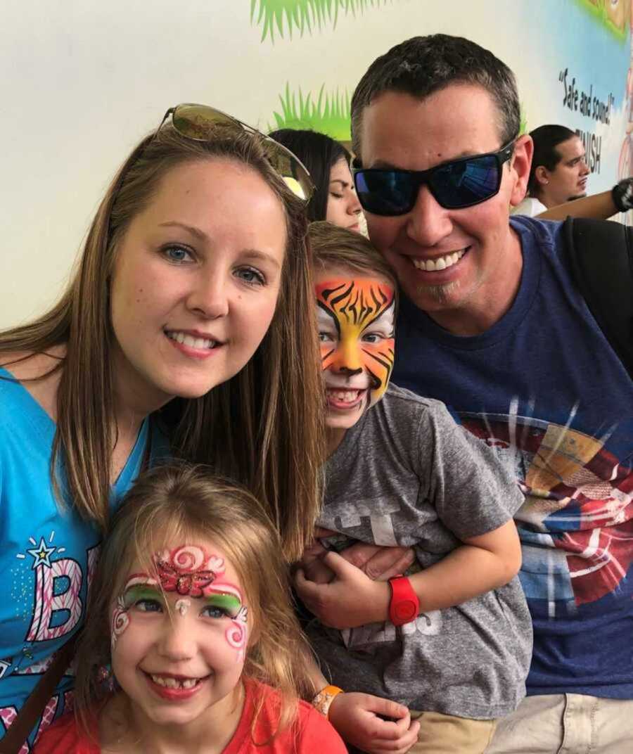 parents standing with kids wearing face paint