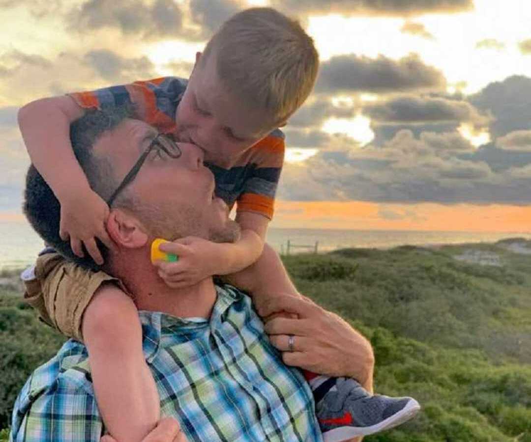 dad holding up son on shoulders