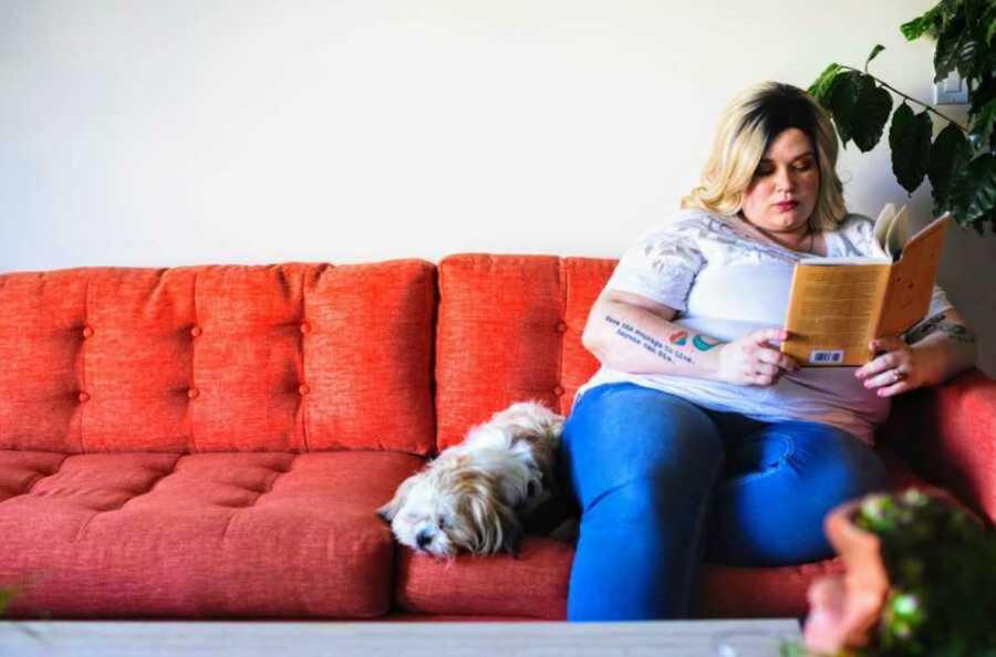 woman reading while sitting on couch