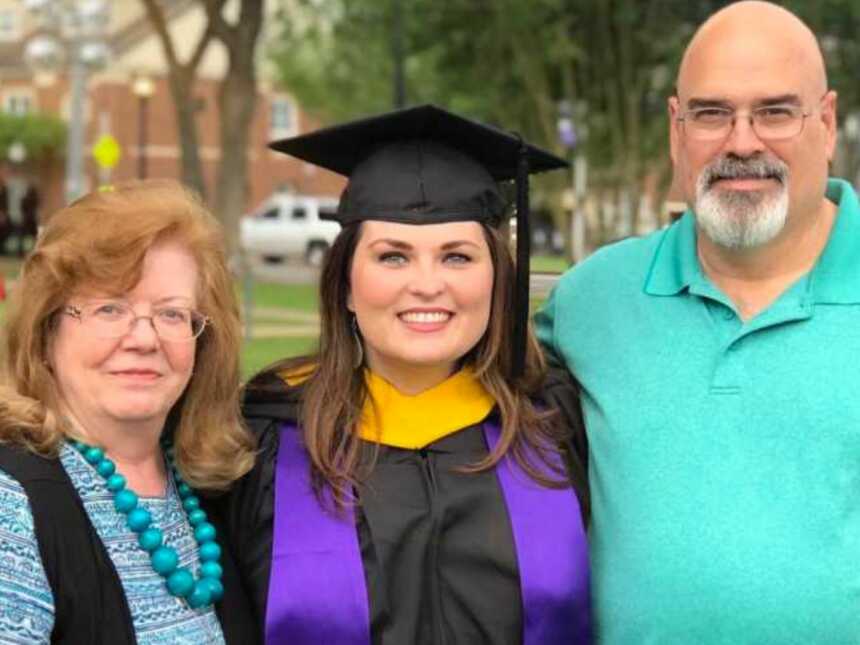 Adoptee standing with adoptive parents