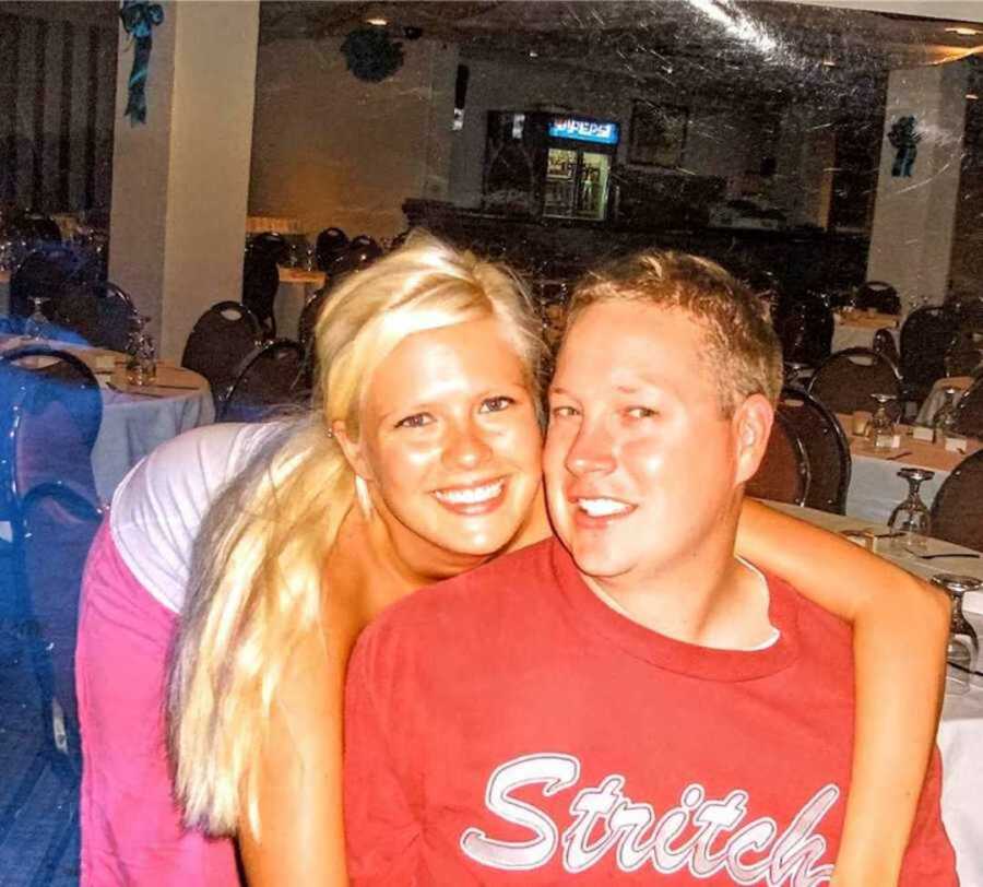 blonde young woman smiling next to boyfriend in restaurant