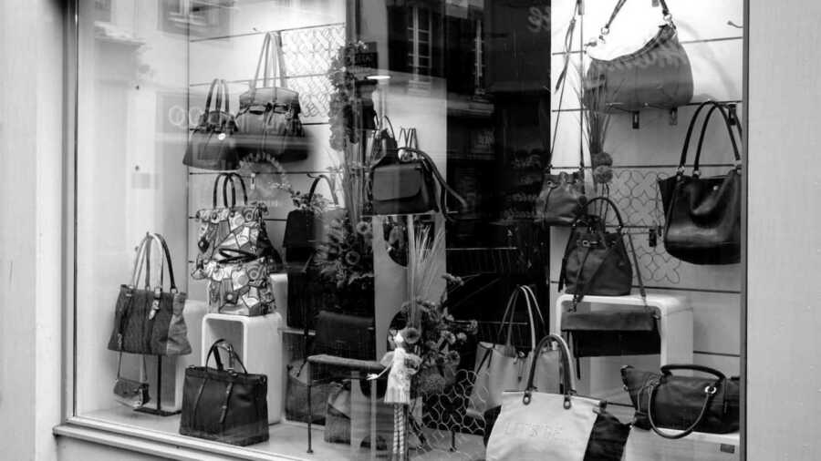 black and white photo of purses on display at mall