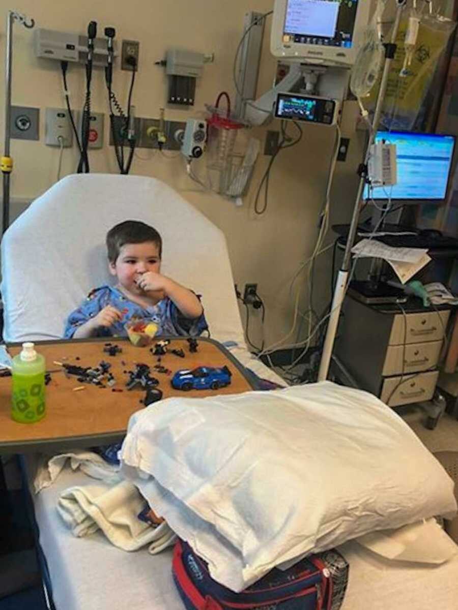 boy playing a game in hospital bed