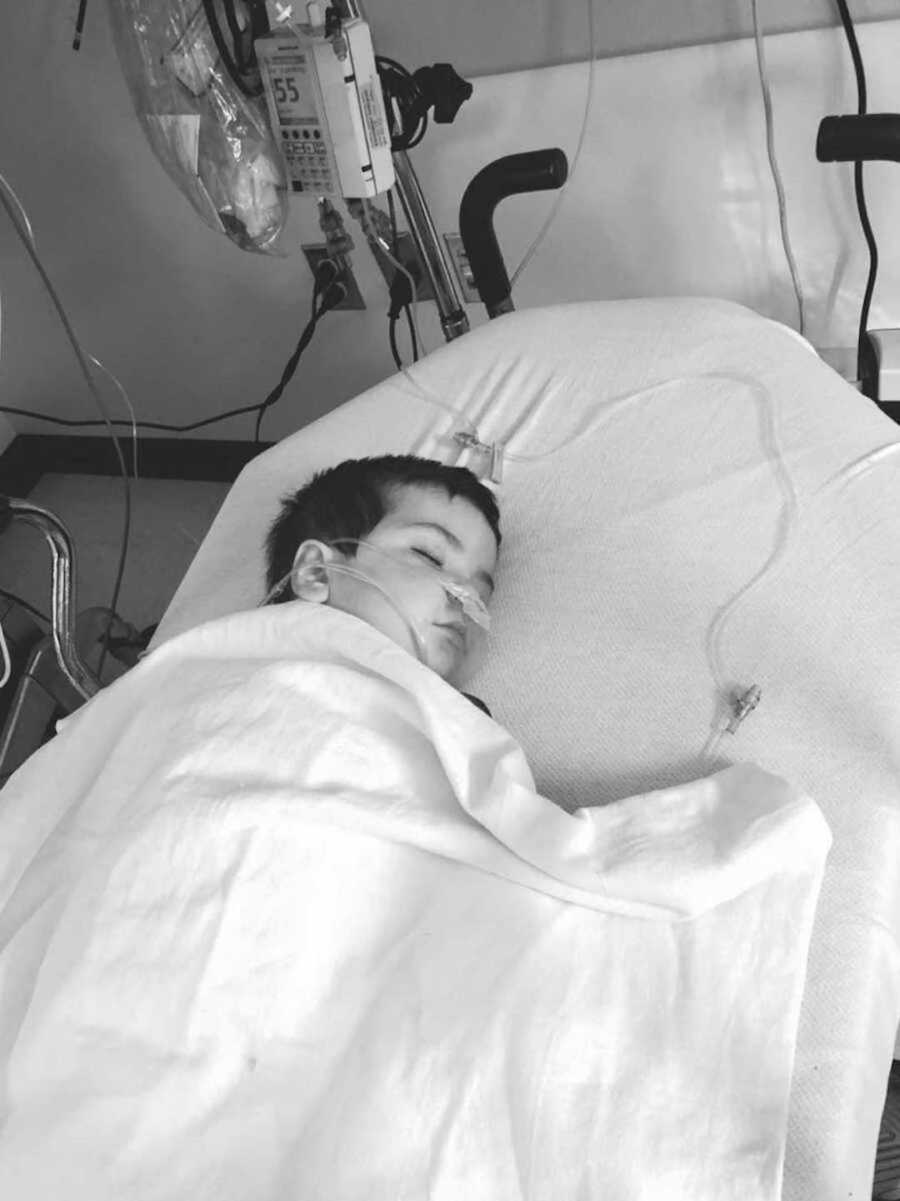 black and white photo of boy sleeping in a hospital bed