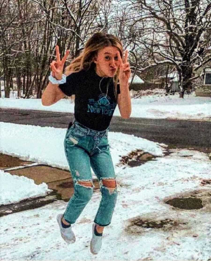 teenage girl jumping outside in snow