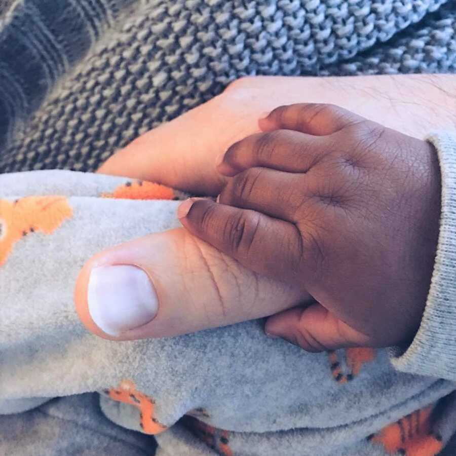 baby hand holding thumb
