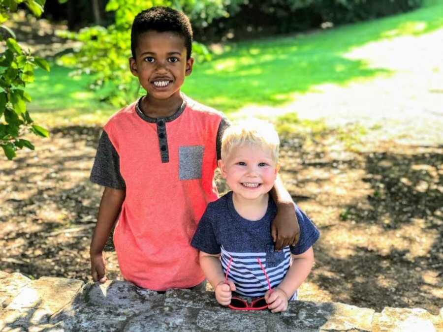 bi-racial brothers standing beside each other outside