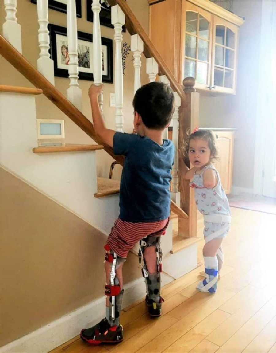 young children with limb differences by staircase