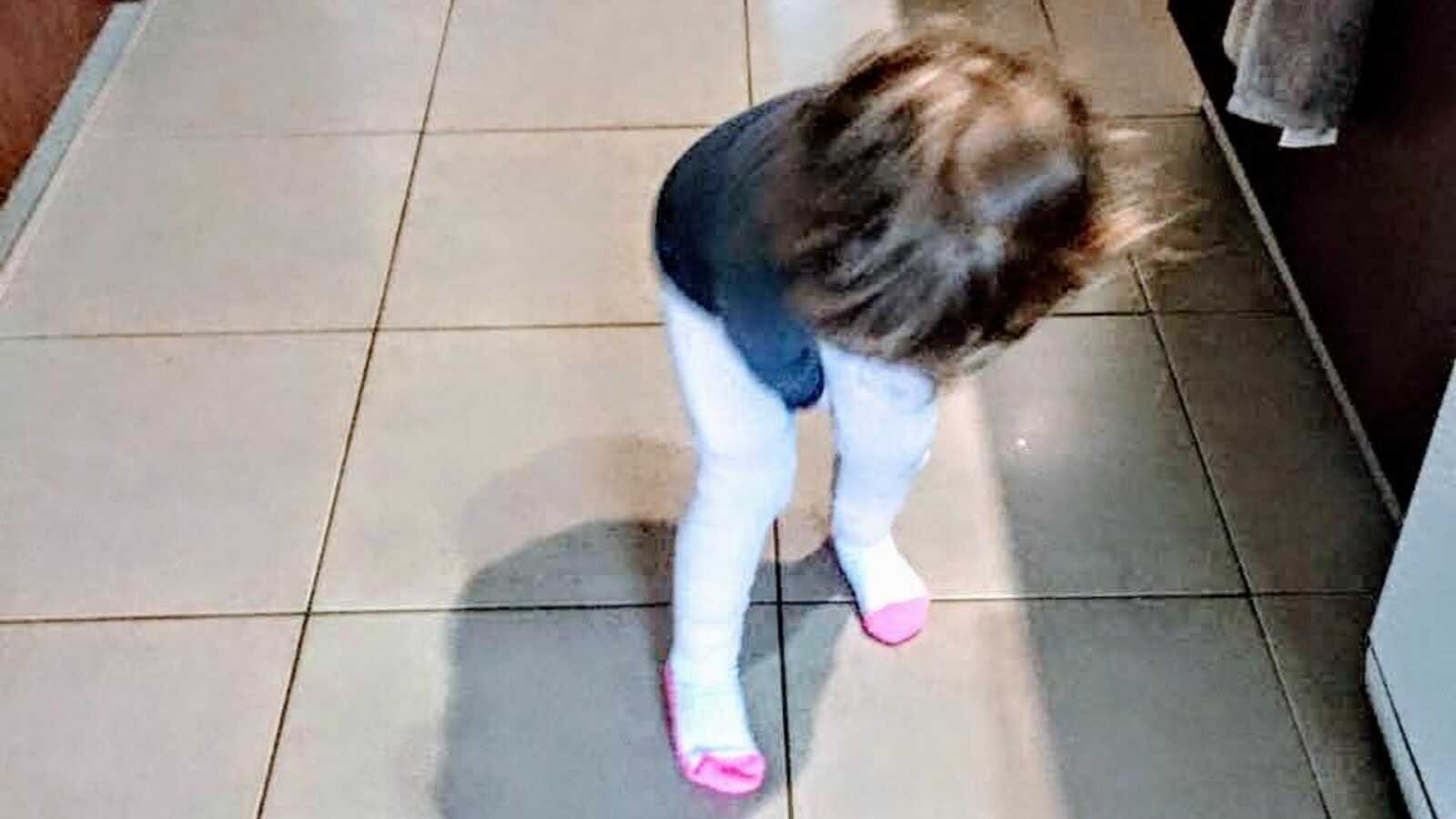 girl standing on tile floor