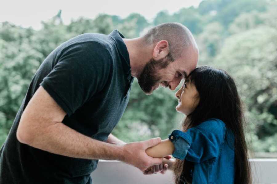 Adoptive dad holding daughter's amputated nubs