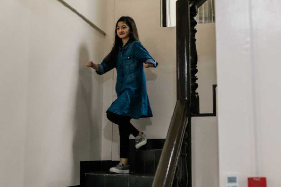 Girl in denim dress walking down stairs