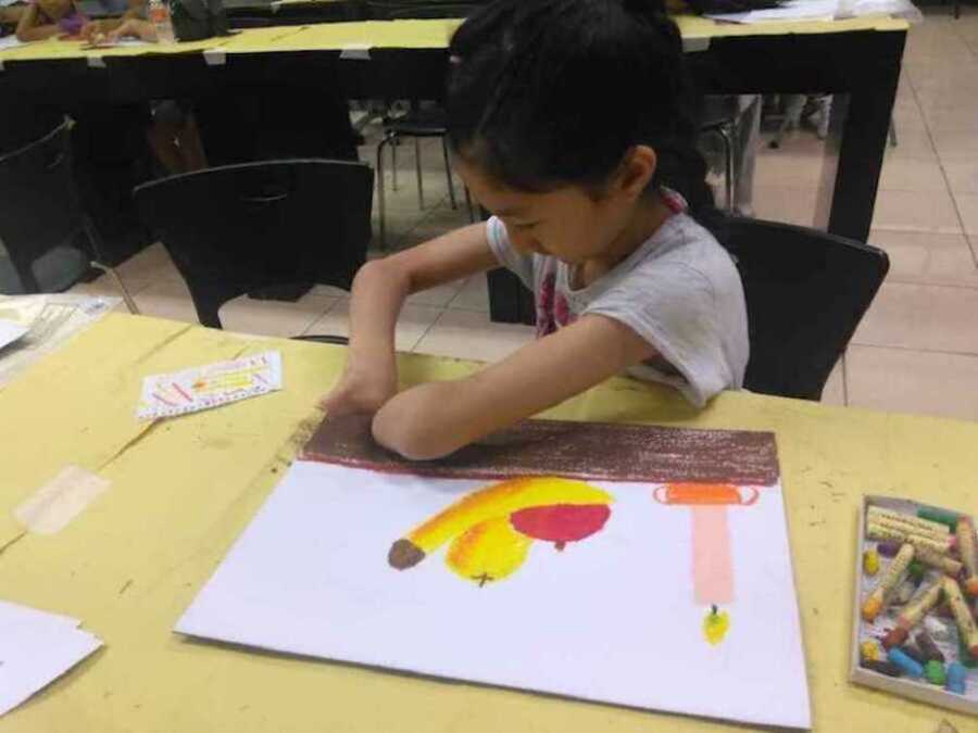 Girl painting with limb difference