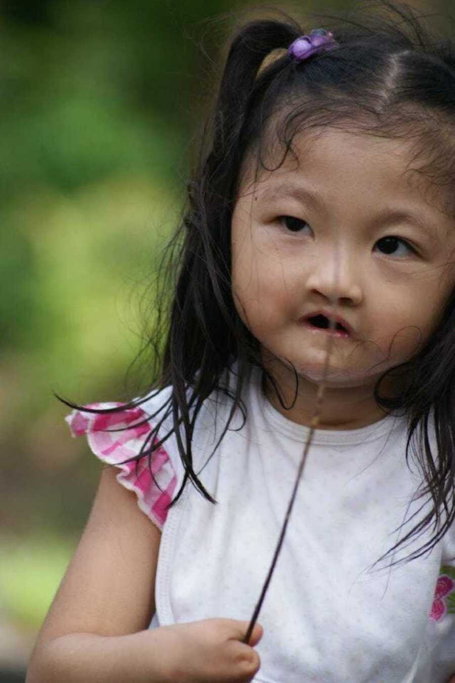 Girl with limb difference playing with stick