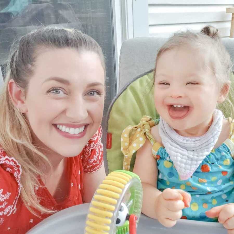mom smiling with young daughter with Down syndrome