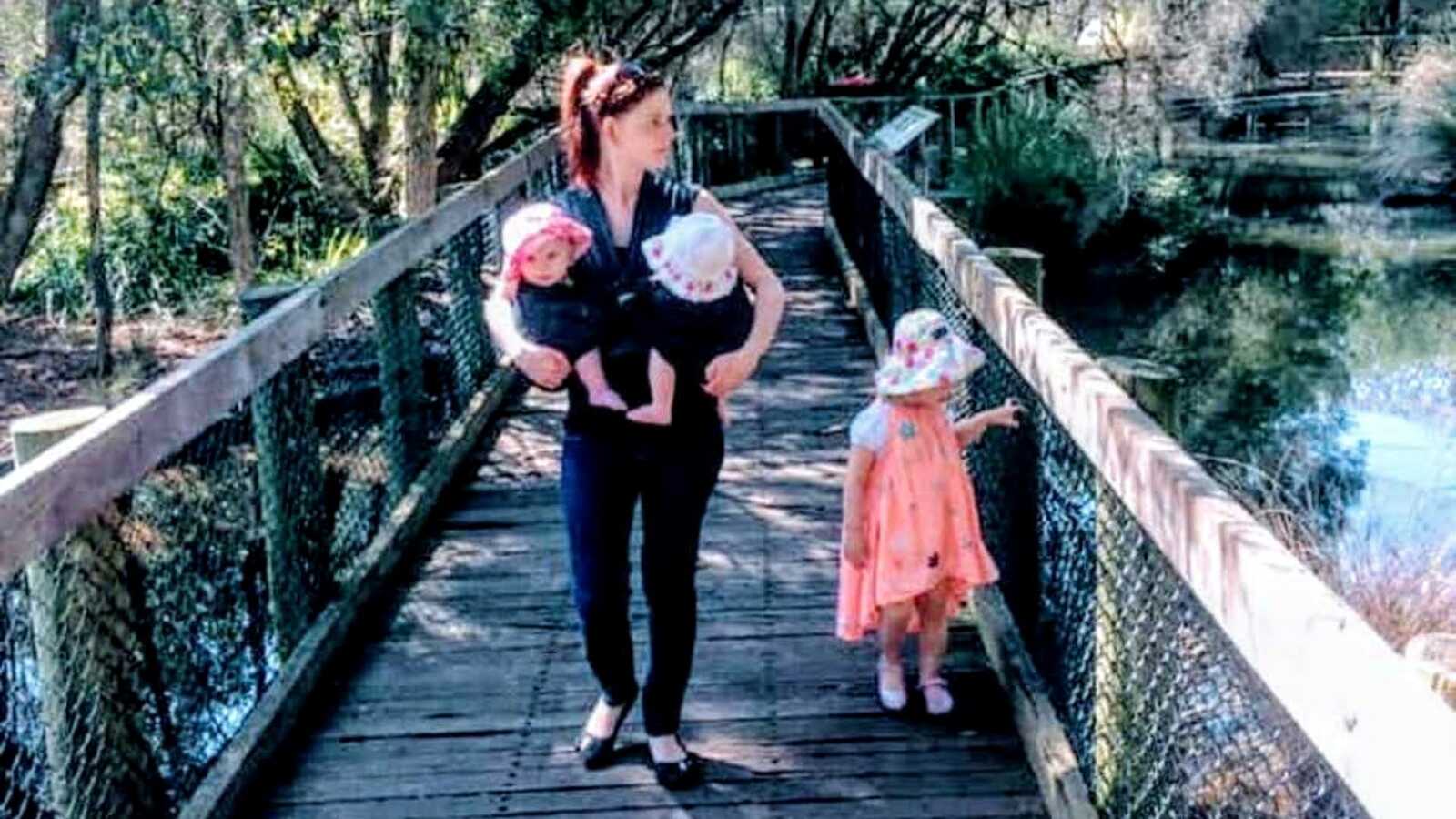 mom walking on bridge with 3 kids