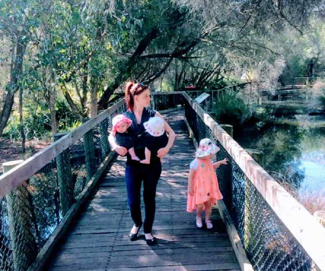 mom walking on bridge with 3 children