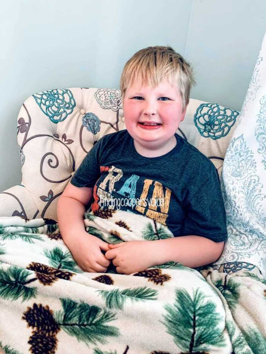 boy smiling while sitting in chair