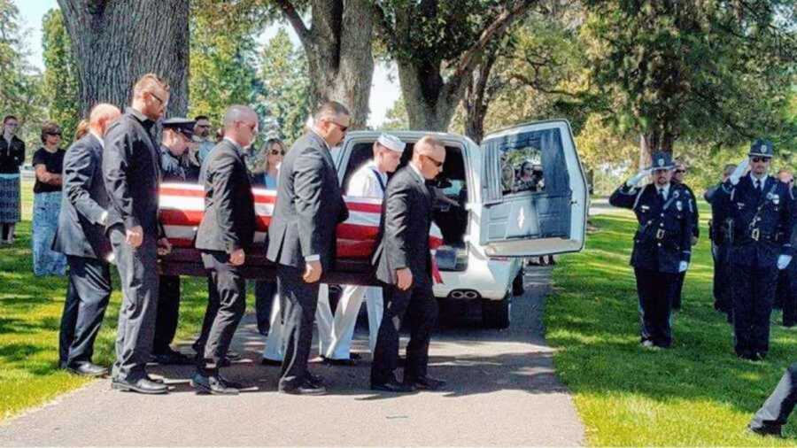 men carrying casket at funeral
