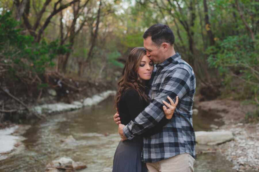 couple hugging outside in forest