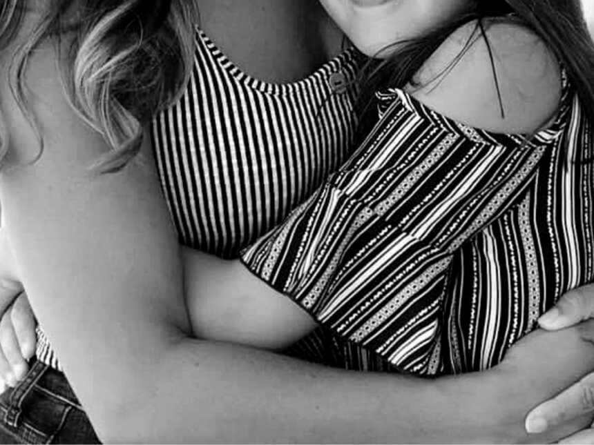 black and white photo of young girl hugging mom