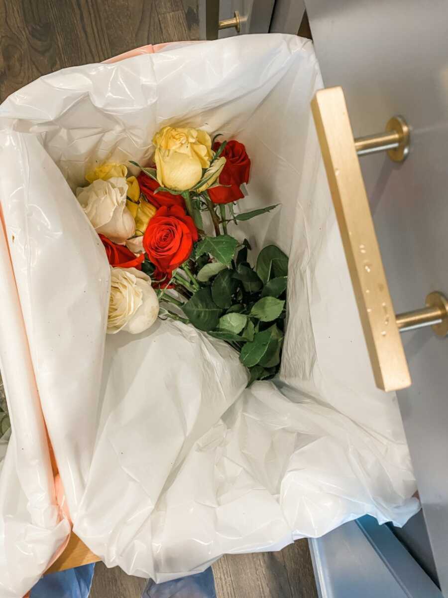 rose bouquet thrown in trash can