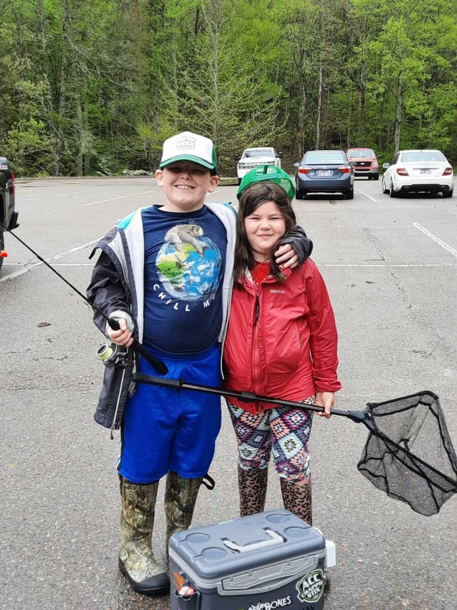 Brother and sister smiling while holding nets