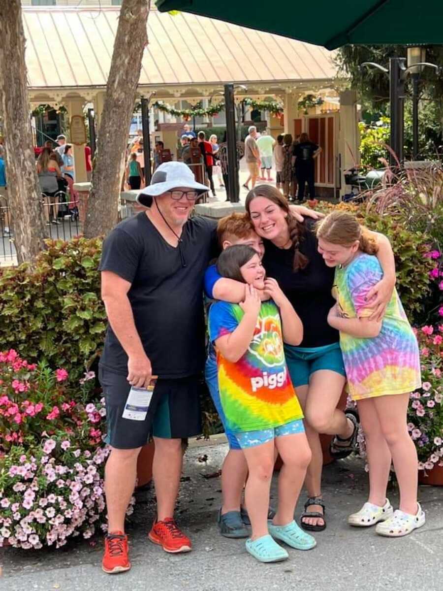 Family hugging girl in tie dye shirt