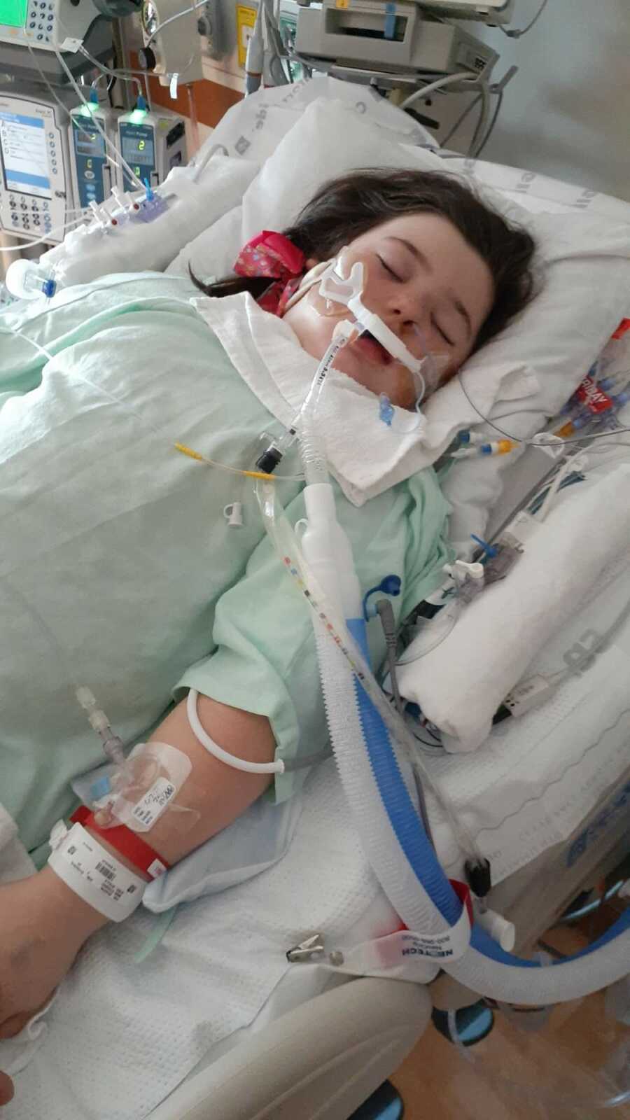 Girl in hospital hooked up to multiple tubes