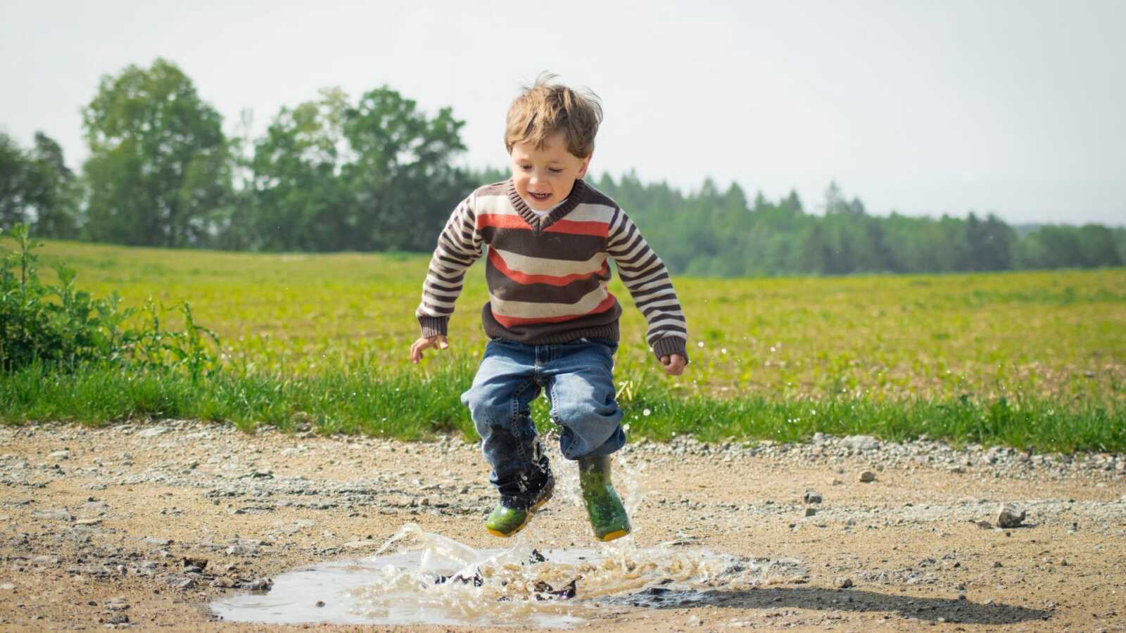 boy jumping in puddle