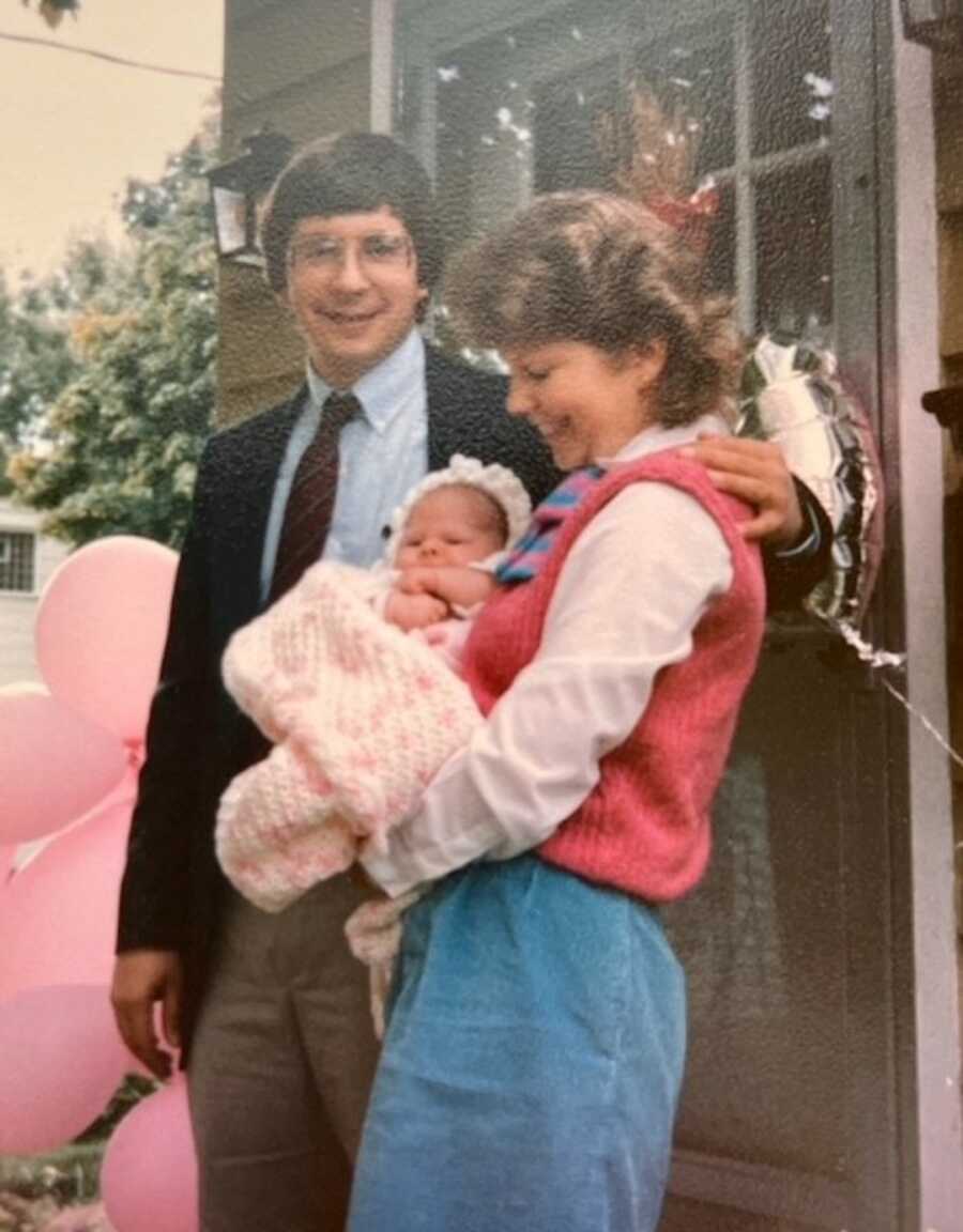 Adoptive parents holding newborn girl