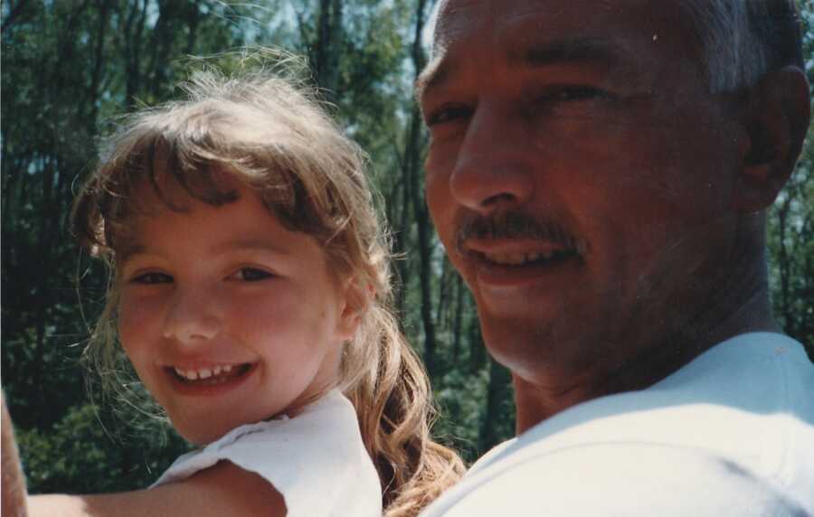 Dad holding little girl in forest