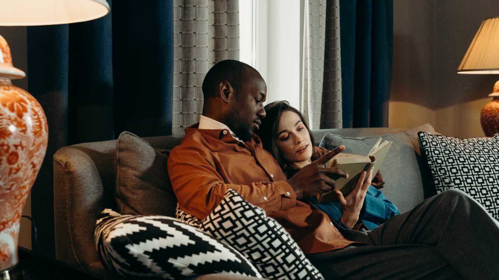 couple reading a book together on a couch