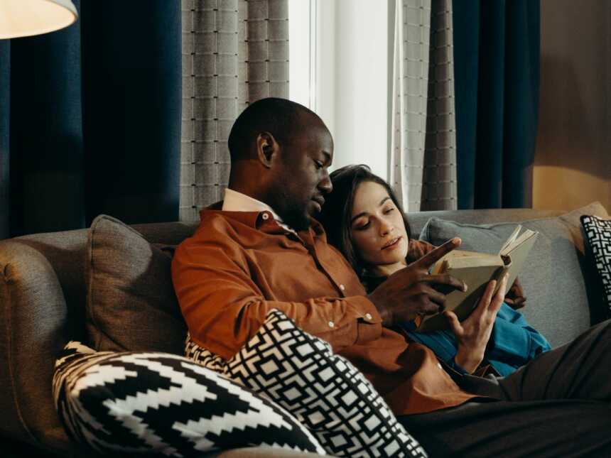 couple reading a book together on a couch