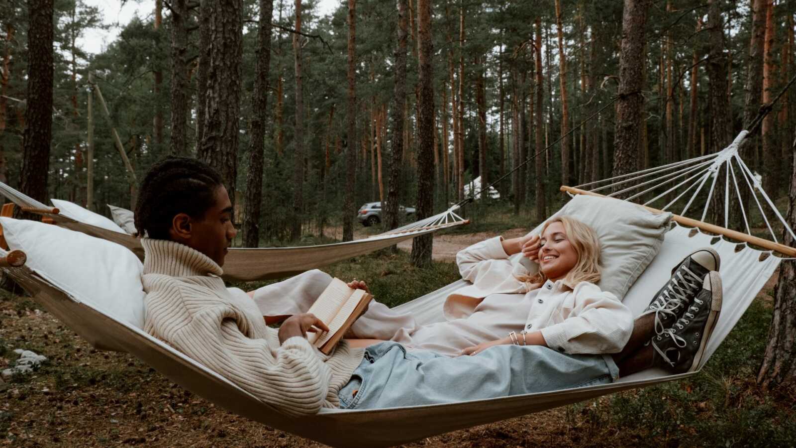 couple reading a book together on a hammock
