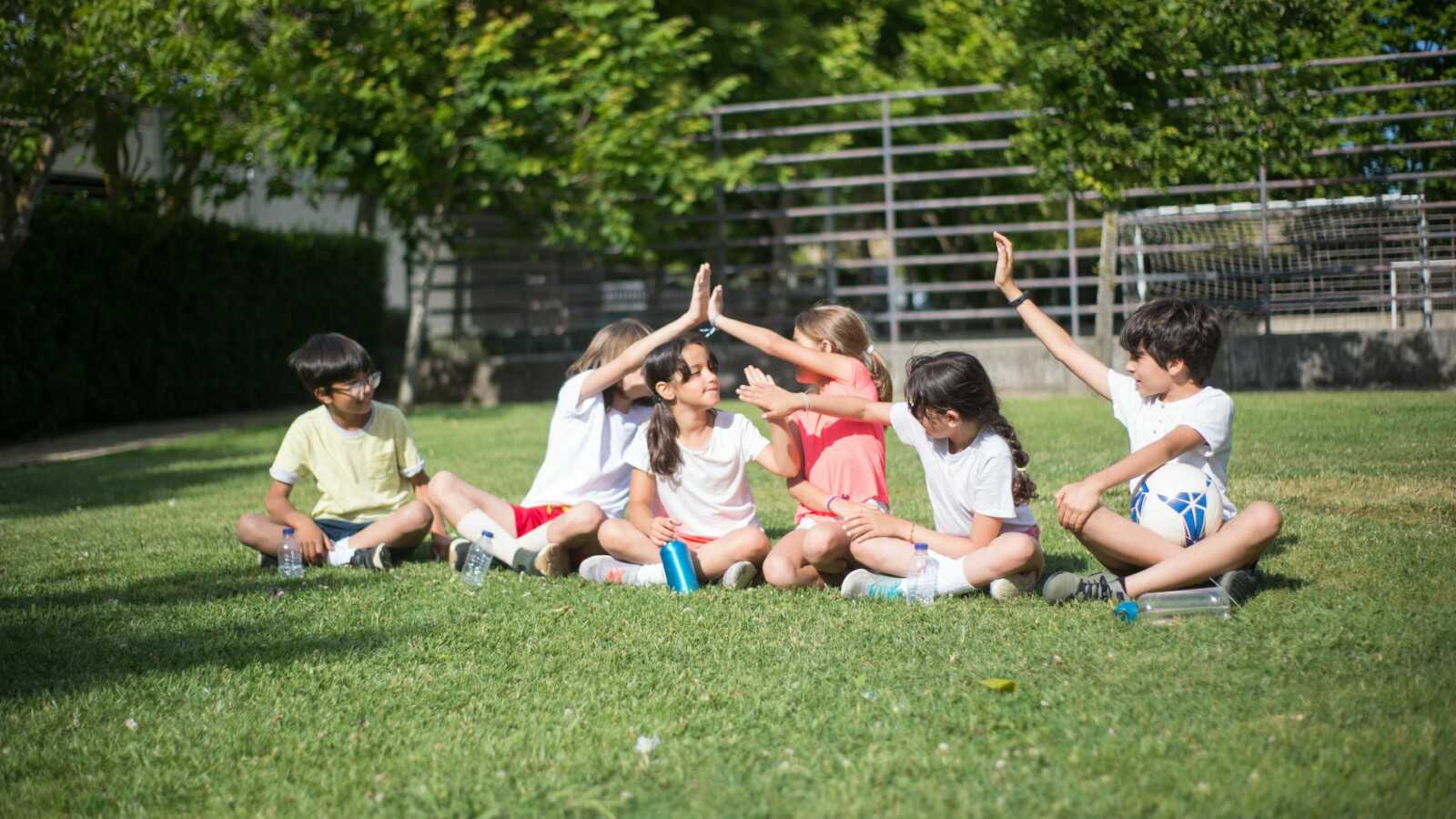 kids on field high fiving