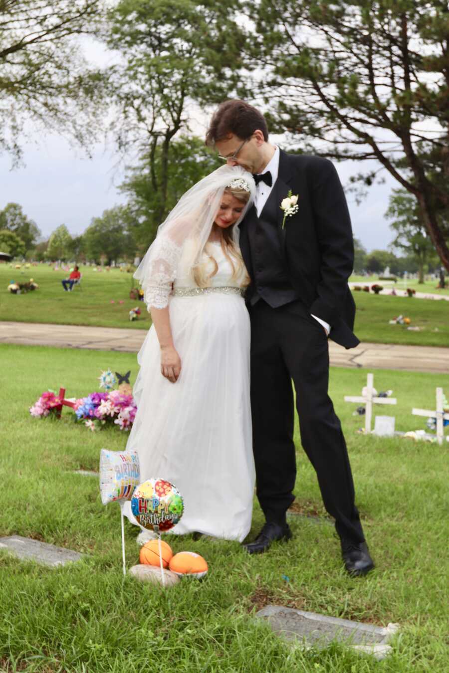 Bride and groom crying at grave site