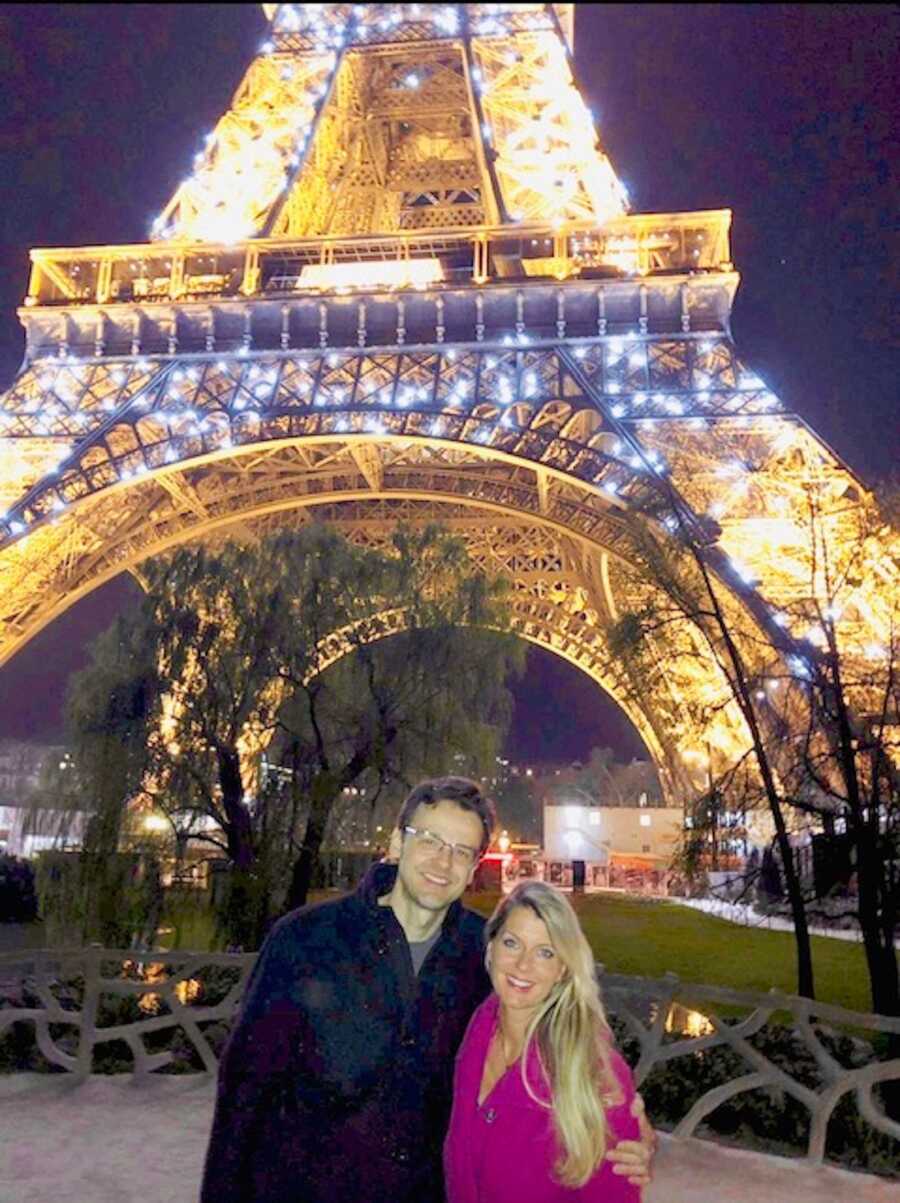 Couple standing in front of Paris Eiffel Tower