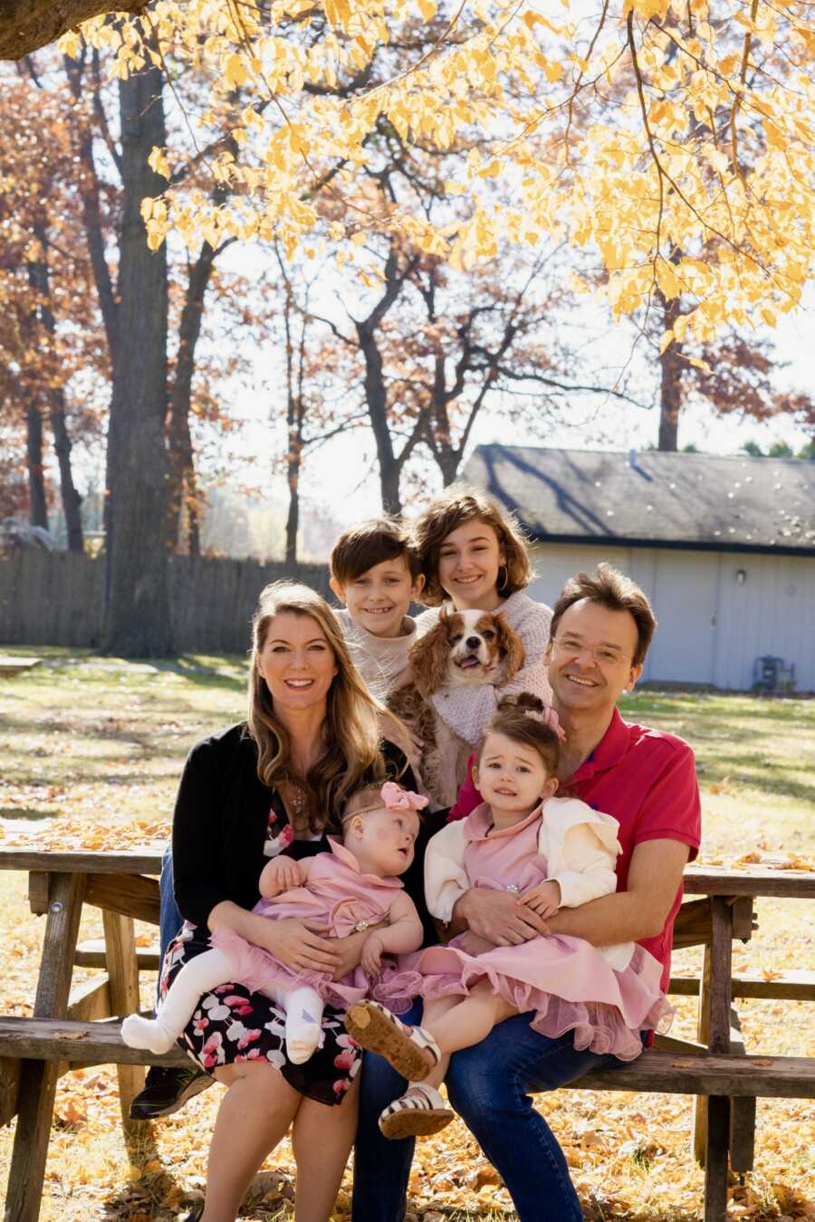 Family sitting on park bench in sun