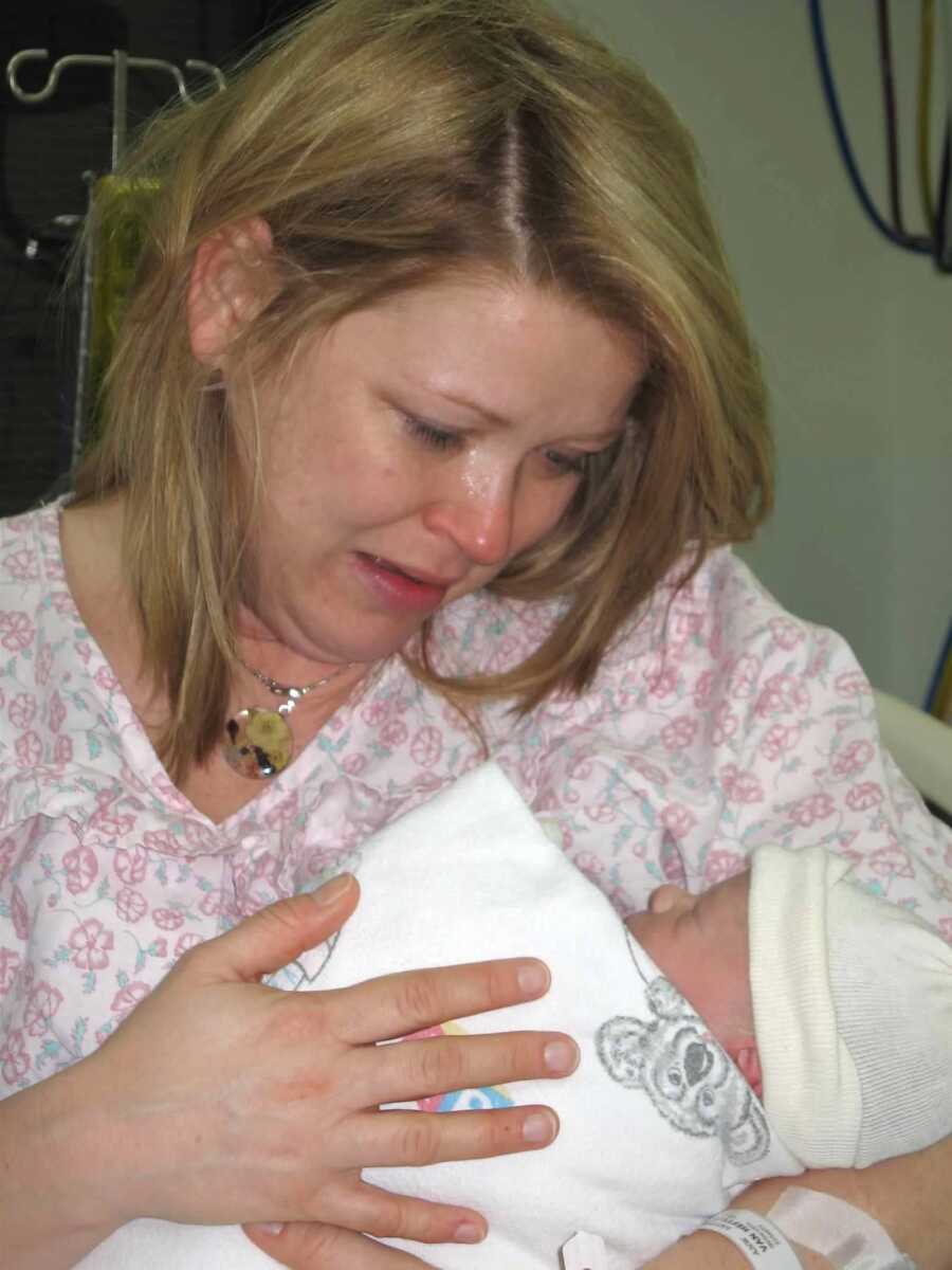 Mom crying while holding newborn boy in hospital