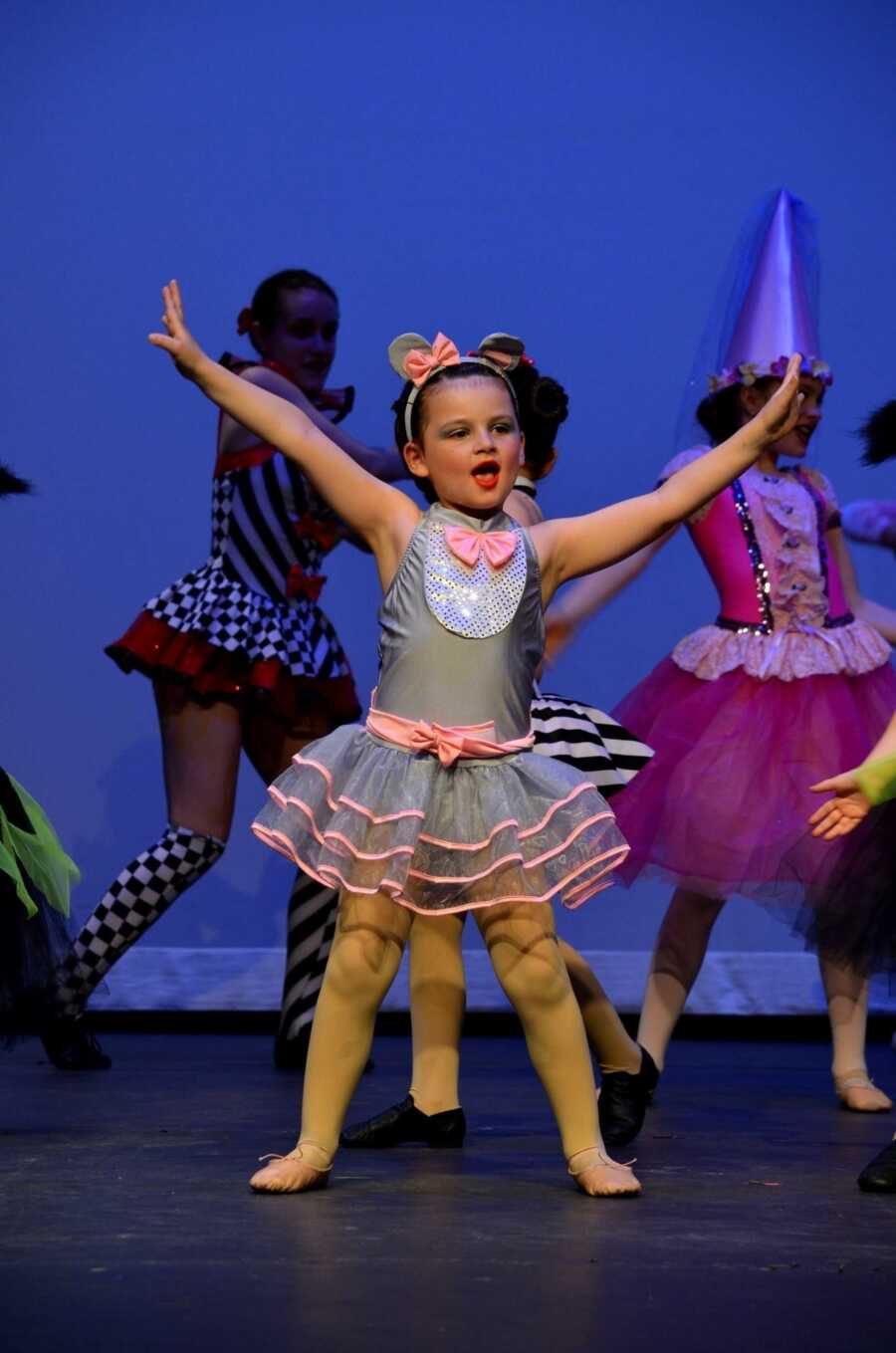 Girl dancing on stage in gray and pink tutu