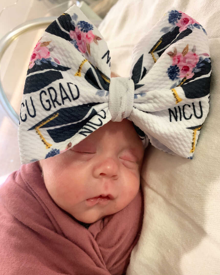 Newborn girl wearing NICU graduate bow