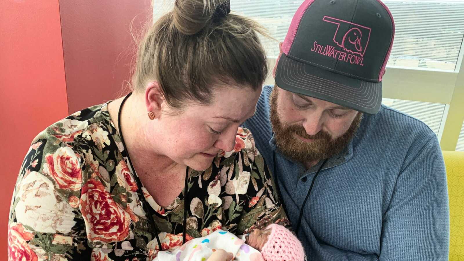 Parents crying while holding newborn in hospital
